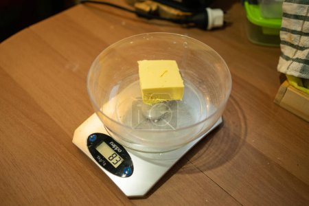 Photo for Weighing Butter on a Kitchen Scale for Cheese Scones - Royalty Free Image
