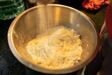 Photo for Adding and Mixing Grated Cheese into the Cheese Scones Mixture - Royalty Free Image
