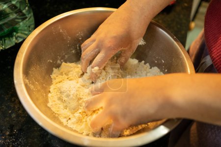 Photo for Girl's Hands Mixing Ingredients for Delicious Cheese Scones Dough - Royalty Free Image