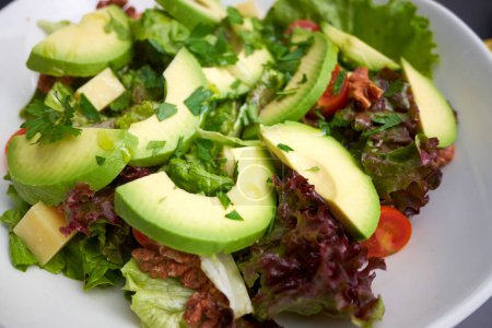 Healthy vegetable salad with avocado and cheese. Mediterranean cuisine.