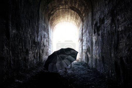 Téléchargez les photos : Parapluie noir solitaire dans un tunnel sombre vide - en image libre de droit