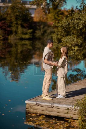 A happy couple in love in casual clothes travel together, hike and have fun in the fall forest on a weekend in nature in autumn outdoors, selective focus. Handsome man embracing with passion his