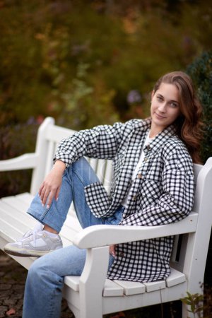 Charming Autumn Casual: Beautiful Girl on Park Bench.