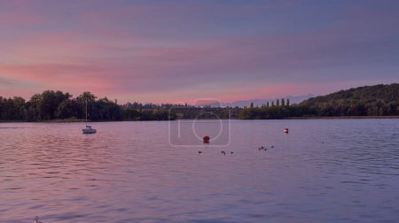 Bodensee Lake Panorama. Tarde, crepúsculo, puesta de sol, pintoresco paisaje, aguas serenas, barcos y yates en el muelle, hermoso cielo con nubes reflejándose en el agua, ribera al atardecer