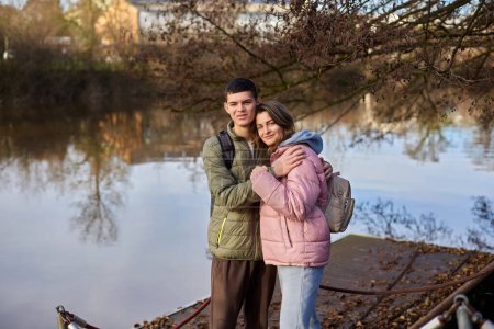 Embracing Moments: Beautiful 35-Year-Old Mother and 17-Year-Old Son in Winter or Autumn Park by Neckar River, Bietigheim-Bissingen, Germany. Celebrate the warmth of family love with this captivating