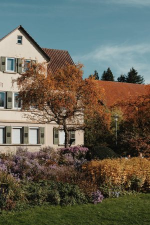 Casa con bonito jardín en otoño. Flores en el parque. Bietigheim-Bissingen. Alemania, Europa. Autumn Park y casa, nadie, arbusto y granizo