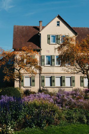 Casa con bonito jardín en otoño. Flores en el parque. Bietigheim-Bissingen. Alemania, Europa. Autumn Park y casa, nadie, arbusto y granizo