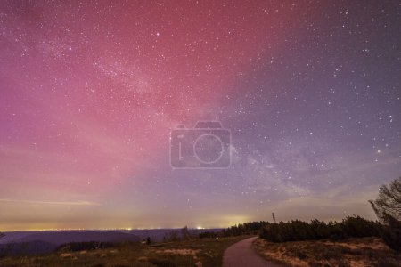 milky way above hornisgride in Baden-wuerttemberg, germany with slight red northern lights on the sky