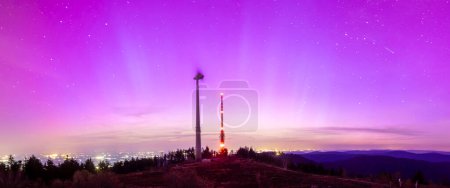 pink colorful northern lights sky above bismarckturm on hornisgride in Baden-wuerttemberg, germany panorama
