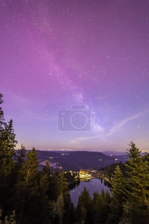 Foto de Vía Láctea por encima de Mummelsee en el bosque negro en Alemania de hornisgrinde con luces boreales rojas leves en la parte superior - Imagen libre de derechos