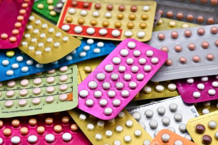 Píldora anticonceptiva oral en el mostrador de farmacia con coloridas pastillas tiras fondo
.