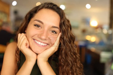 Téléchargez les photos : Portrait d'une femme heureuse avec un sourire parfait dans un restaurant qui vous regarde - en image libre de droit