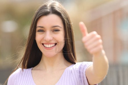 Photo for Happy teen gestures thumb up standing in the street - Royalty Free Image