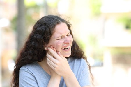 Femme souffrant mal à la mâchoire dans la rue