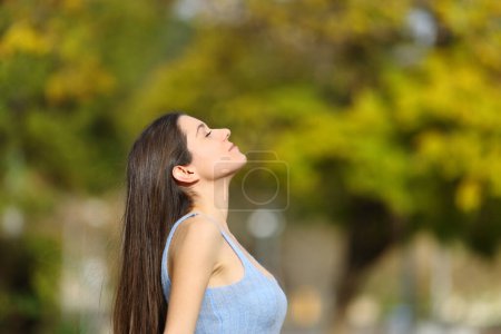 Téléchargez les photos : Profil d'un adolescent respirant de l'air frais dans un parc - en image libre de droit