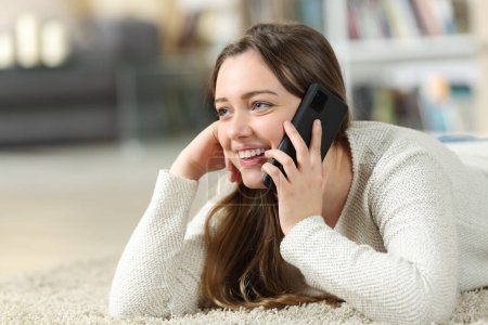Photo for Happy teen talking on phone on the floor at home - Royalty Free Image