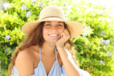 Foto de Portrait of a beautiful woman smiling at camera sitting in a park - Imagen libre de derechos