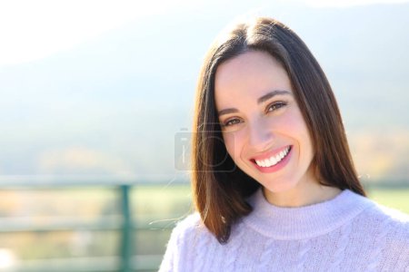 Foto de Portrait of a happy woman with white tooth standing in nature looking at camera - Imagen libre de derechos