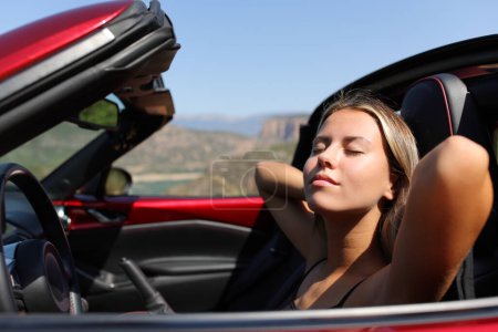 Photo for Convertible car driver resting a sunny day in the mountain - Royalty Free Image