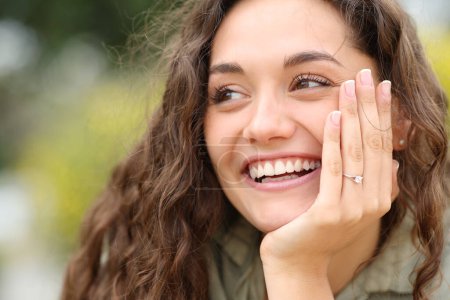 Téléchargez les photos : Happy fiencee smiling showing ring at camera in a park - en image libre de droit