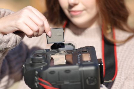 Foto de Fotógrafo cambia la tarjeta de mano en la cámara profesional dslr - Imagen libre de derechos