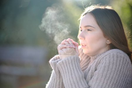 Téléchargez les photos : Femme respirant et se refroidissant en hiver dans un parc - en image libre de droit