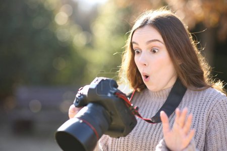 Photo for Amazed photographer checking photos on camera in winter - Royalty Free Image