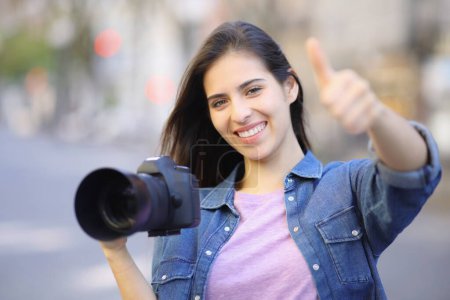Photo for Happy photographer gesturing thumb up in the street - Royalty Free Image