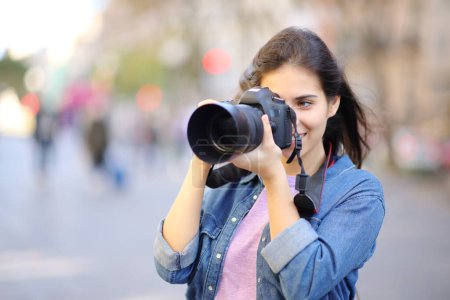 Photo for Happy photographer taking photos standing in the street with dslr camera - Royalty Free Image