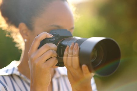 Foto de Fotógrafo negro tomando fotos con cámara sin espejo en un parque - Imagen libre de derechos