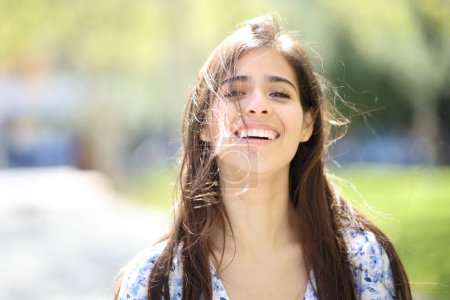 Foto de Retrato de una mujer feliz riéndose con el pelo alborotado un día ventoso - Imagen libre de derechos
