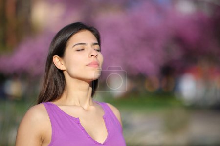 Frau auf Violett atmet frische Luft in einem Park