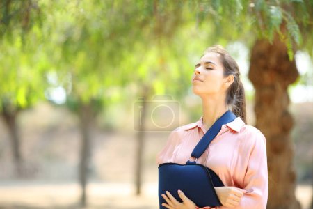 Foto de Mujer convaleciente respirando aire fresco en un parque - Imagen libre de derechos