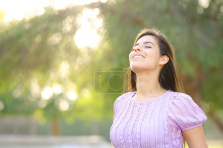 Photo for Happy woman breathing fresh air standing in a park - Royalty Free Image