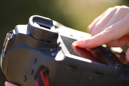 Téléchargez les photos : Gros plan portrait d'un doigt de photographe à l'aide d'un écran tactile sur appareil photo professionnel - en image libre de droit