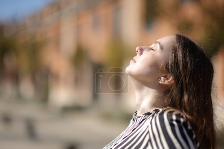 Foto de Retrato vista lateral de una mujer elegante respirando aire frens en una zona residencial - Imagen libre de derechos