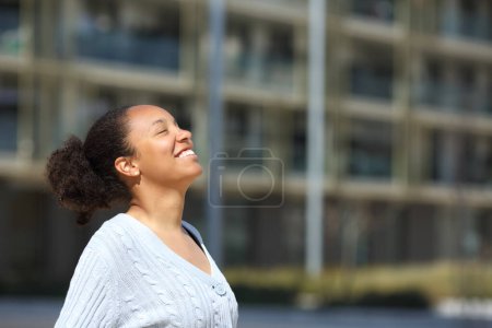 Photo for Happy black woman breathing fresh air in the street - Royalty Free Image