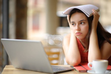 Foto de Estudiante frustrado distrayéndose mirando hacia otro lado sentado en una terraza del bar - Imagen libre de derechos