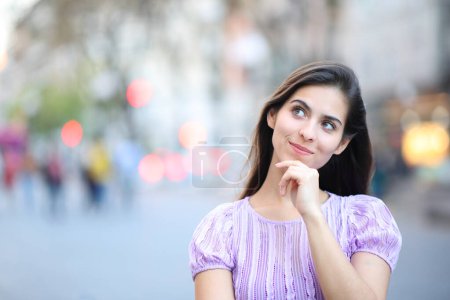 Photo for Front view portrait of a woman thinking looking at side in the street - Royalty Free Image