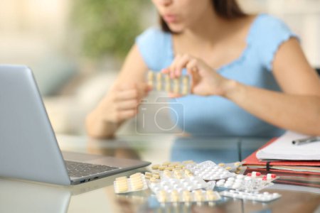 Photo for Closeup of a student taking a lot of pills at home - Royalty Free Image