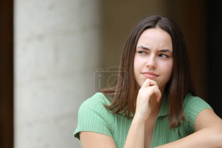 Photo for Front view portrait of a pensive woman in the street looks at side - Royalty Free Image