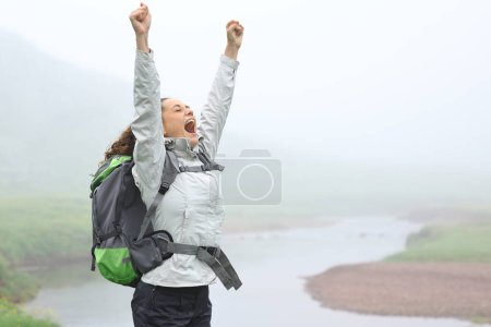 Foto de Feliz caminante levantando brazos celebrando en la naturaleza - Imagen libre de derechos