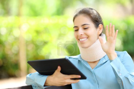 Photo for Convalescent businesswoman having videocall on tablet in a park - Royalty Free Image