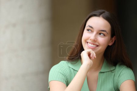 Téléchargez les photos : Femme heureuse dans la rue pensant à côté - en image libre de droit