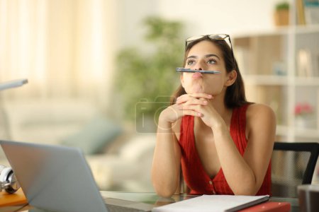 Téléchargez les photos : Étudiant ennuyé avec ordinateur portable perdre du temps assis à la maison - en image libre de droit