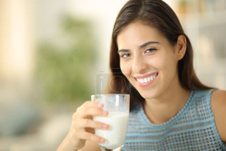 Téléchargez les photos : Happpy femelle boire du lait avec des lèvres sales à la maison - en image libre de droit
