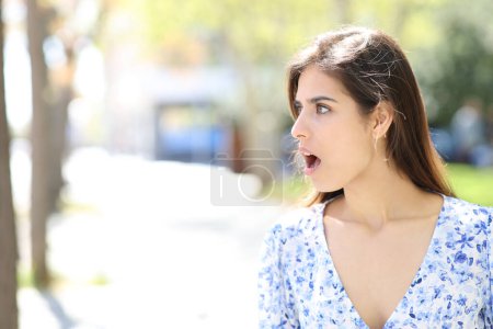Téléchargez les photos : Femme surprise regardant côté debout dans la rue - en image libre de droit