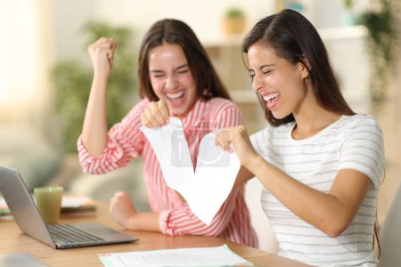 Photo for Two happy tele workers breaking contract celebrating at home - Royalty Free Image