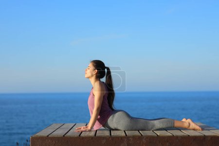 Photo for Profile of a yogi doing yoga exercise in a coast resort - Royalty Free Image