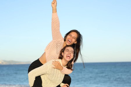 Foto de Amigos divertidos bromeando y celebrando riendo en voz alta en la playa - Imagen libre de derechos